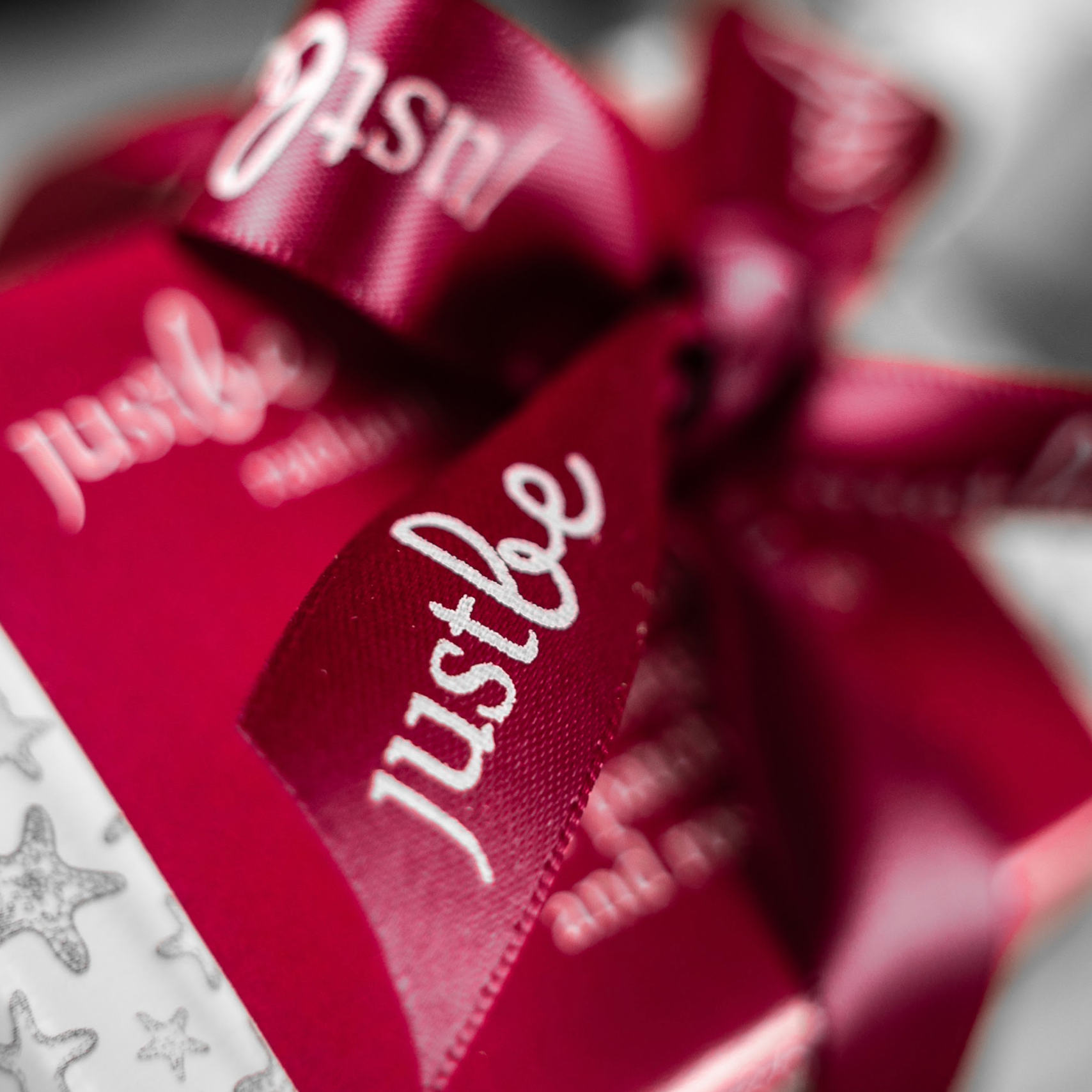 Close-up of a JustBe red ribbon on a blurred background