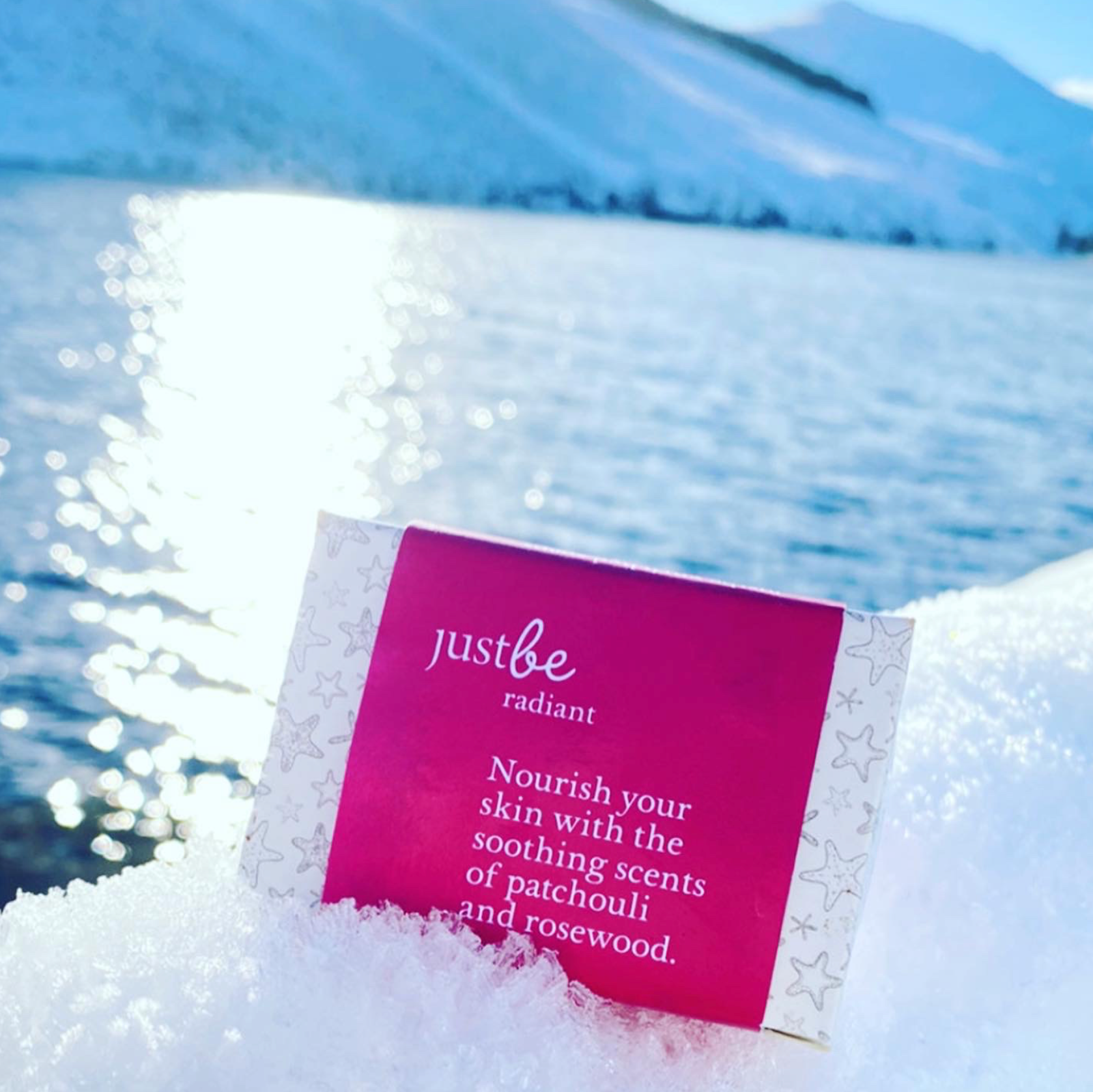 Bar of JustBe Radiant Soap against a snowy landscape