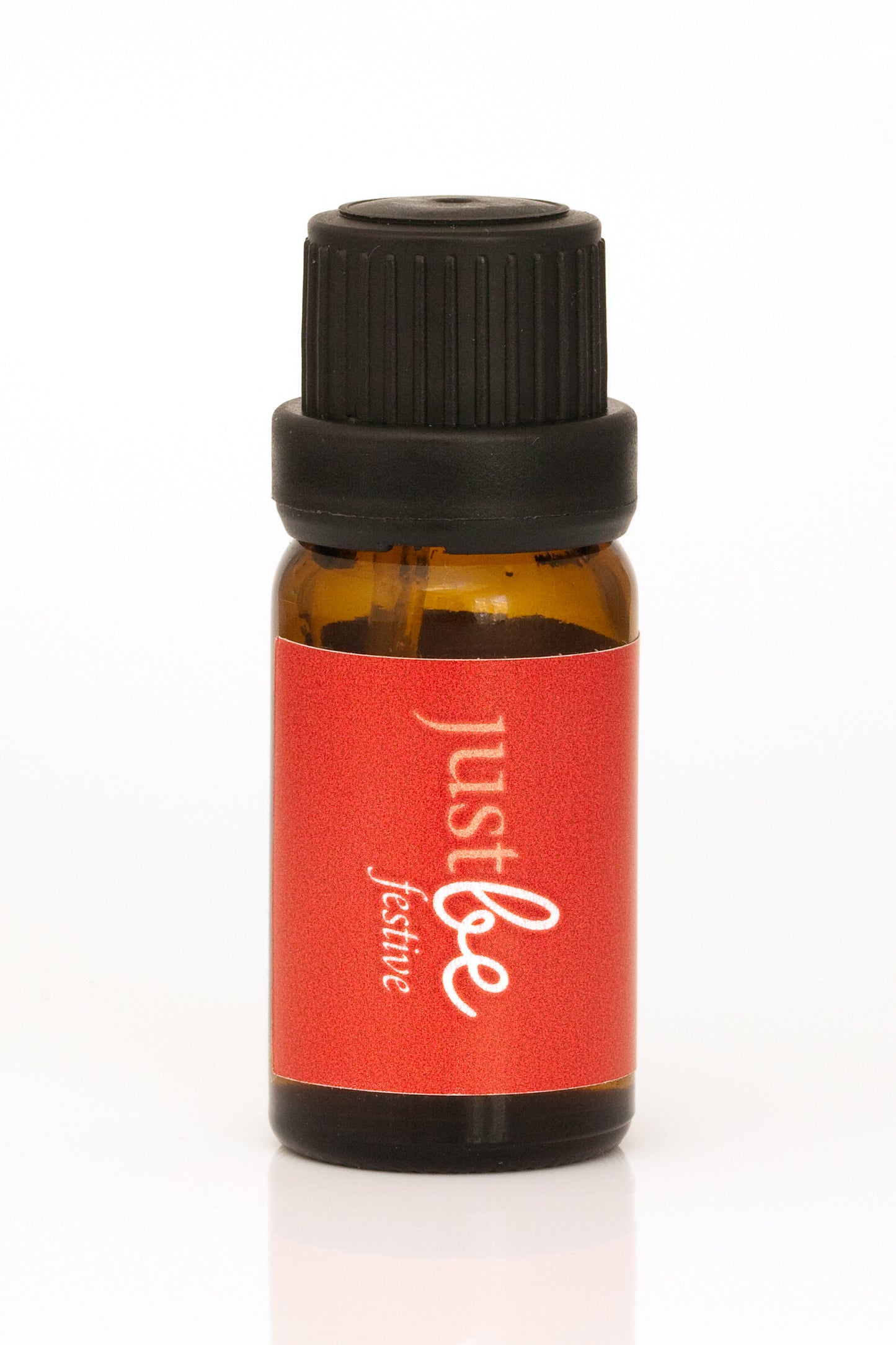 Bottle of JustBe Festive Burning Oil 10ml - red label and black dropper top.