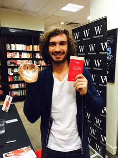 Joe Wichs holiding JustBe Loved award and bar of chocolate in Waterstones Edinburgh