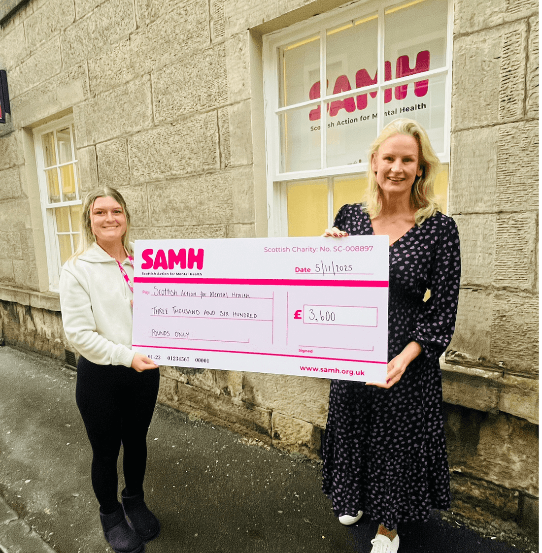 Gail Bryden founder of JustBe Botanicals handing charity cheque to SAMH