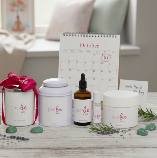 JustBe Kind range of candle, herbal tea, massage oil, rollerball & body butter sitting on living room table with candler in the back with October 10th circled