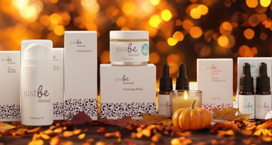 JustBe Botanicals skincare surrounded by Autumn leaves with warm lights twinkling in background