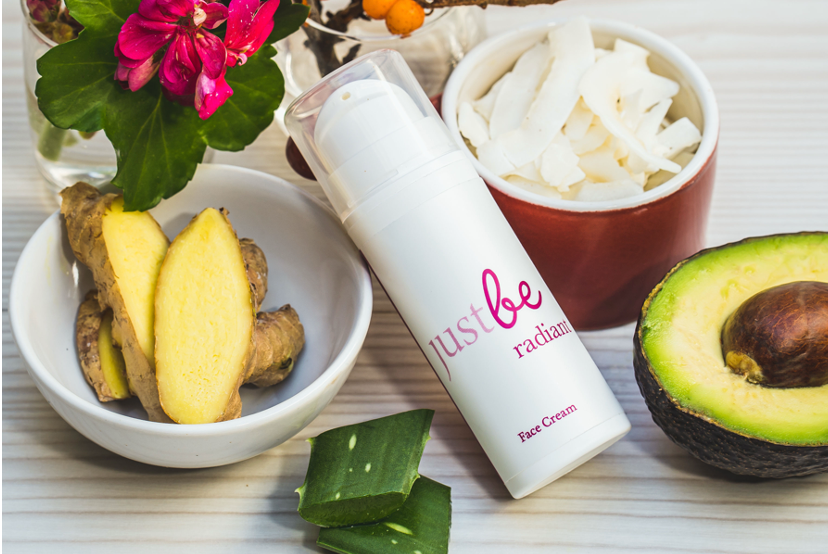 JustBe Botanicals Face Cream surrounded by nutrient dense natural ingredients