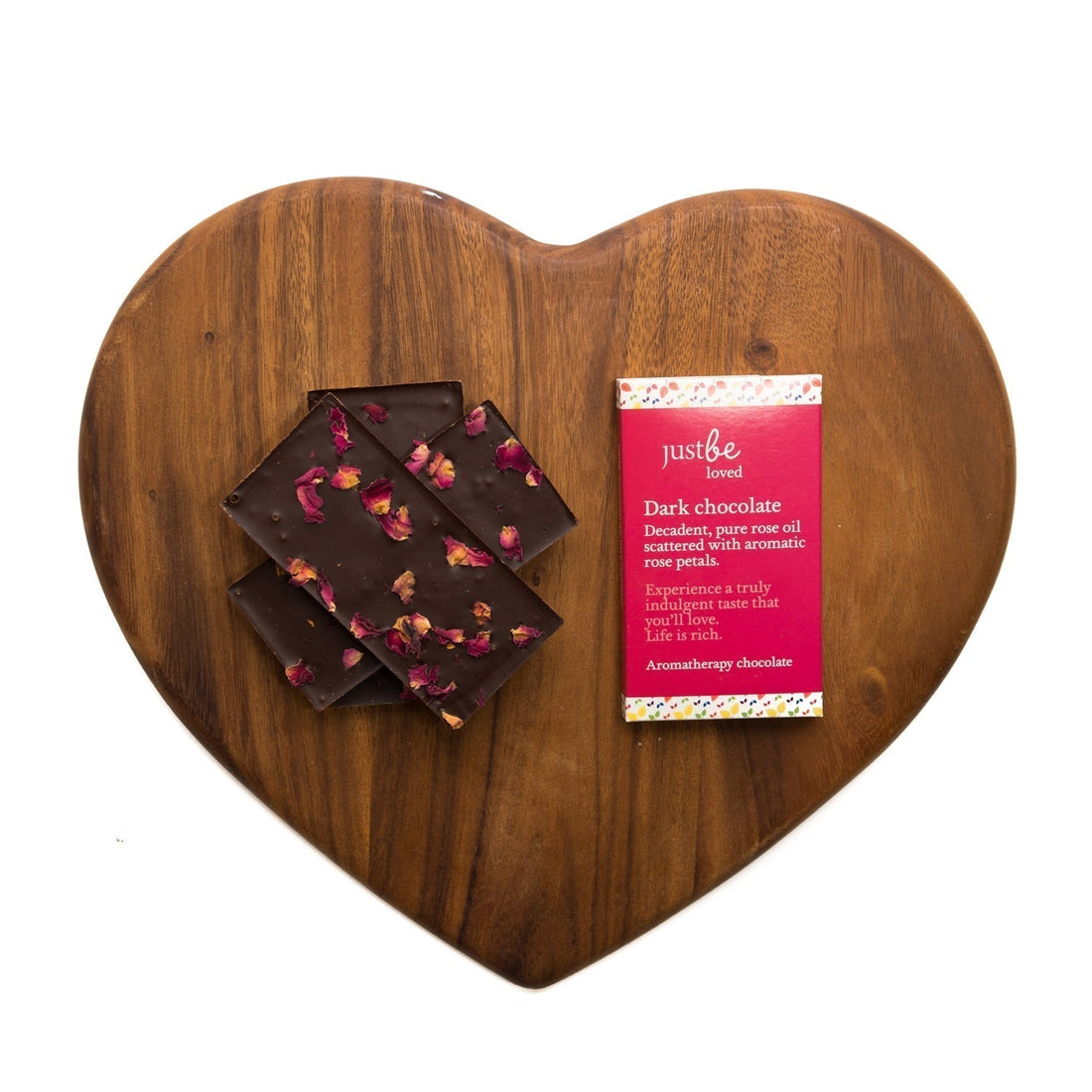 Bars of JustBe Loved chocolate piled on top of heart shaped wooden board