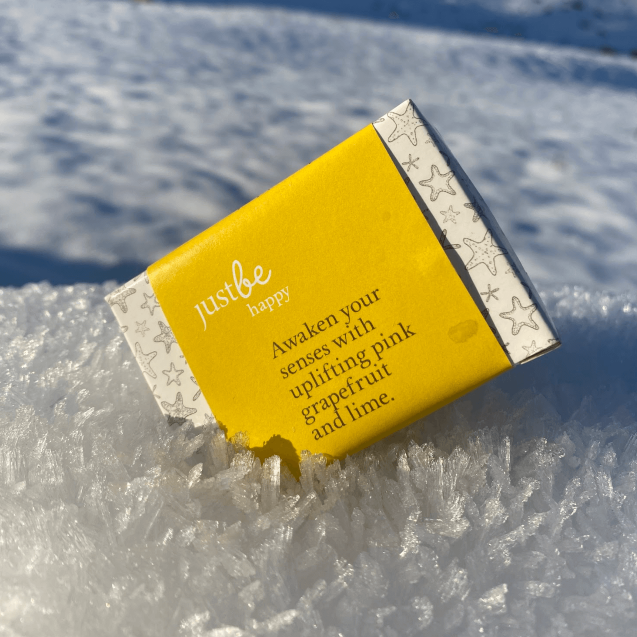 Bar of JustBe Happy soap on a snowy surface