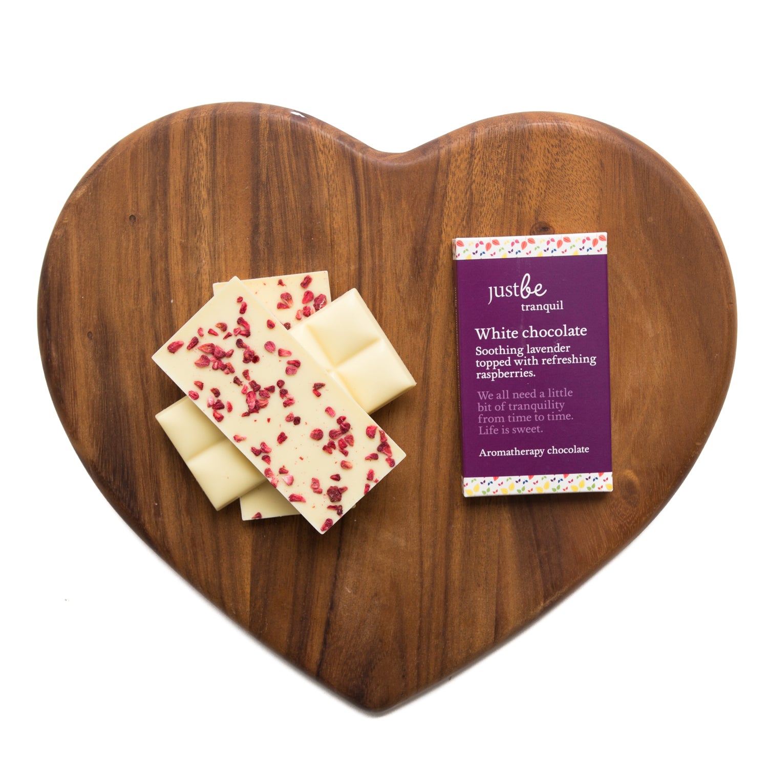 Heart-shaped wooden board with white chocolate bars and a JustBe card on a white background