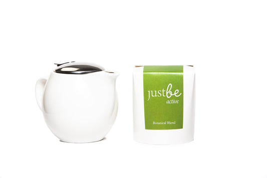 Modern white teapot with removable strainer shown beside JustBe Active loose leaf herbal tea in a white box with bright green label.