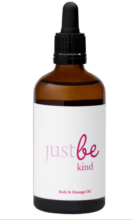 Bottle of 'just be kind' body and massage oil with a white label on a white background